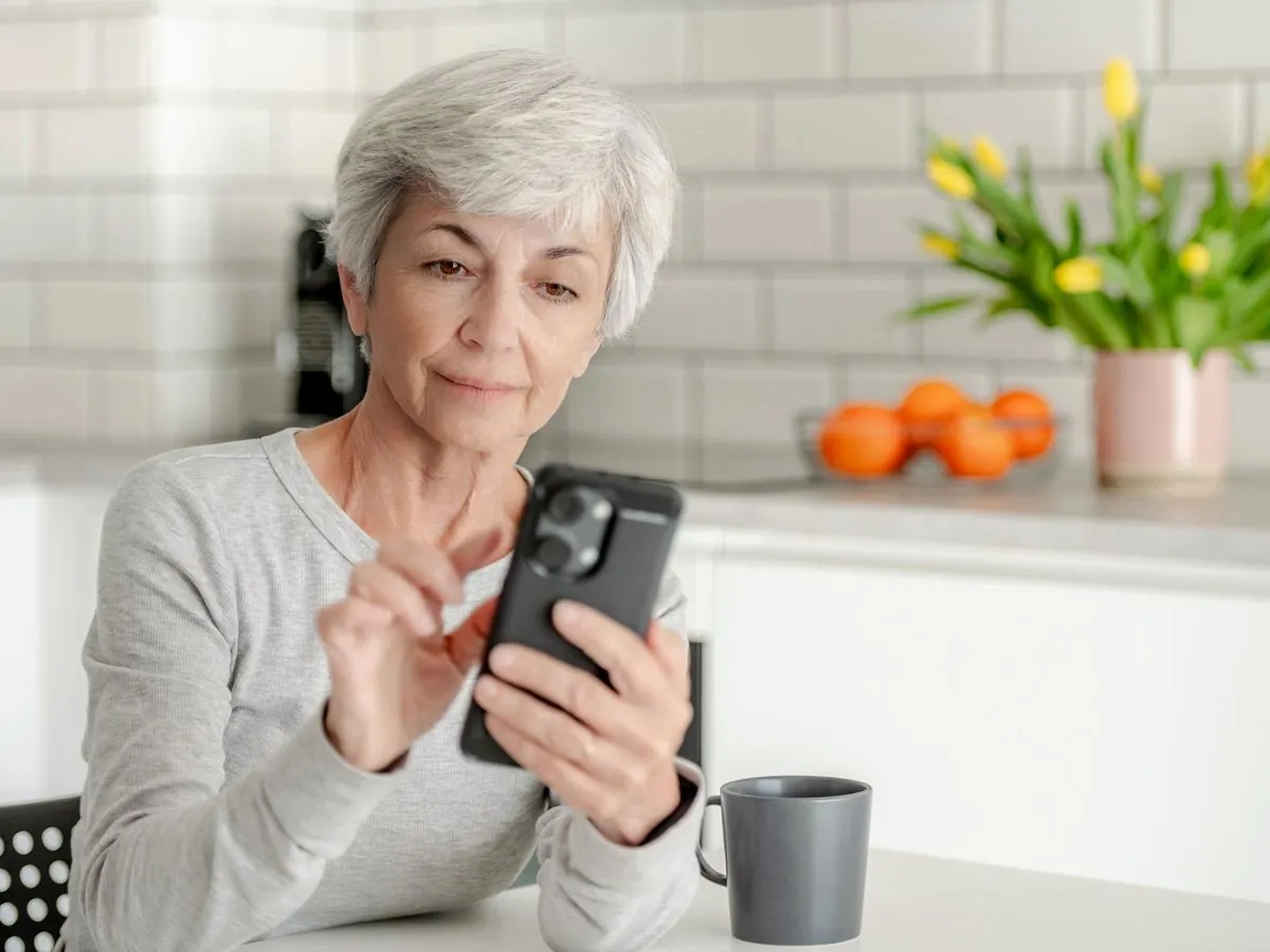 A homeowner searching on her phone at the kitchen table