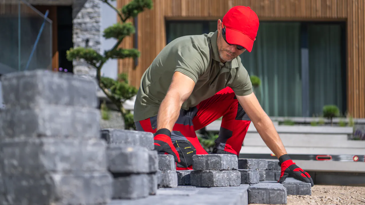 Paver in a red cap bedding grey block paving in front of a modern house