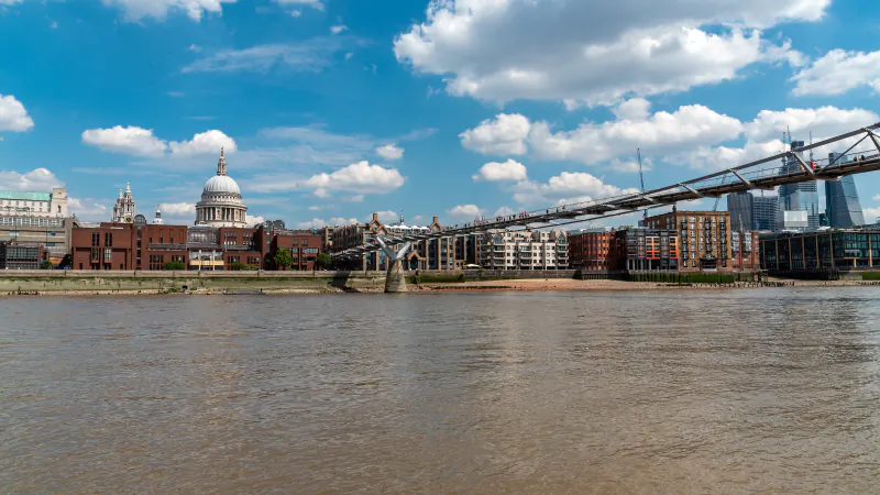 St Paul's Cathedral and the Millennium Bridge seen across the River Thames on a sunny day