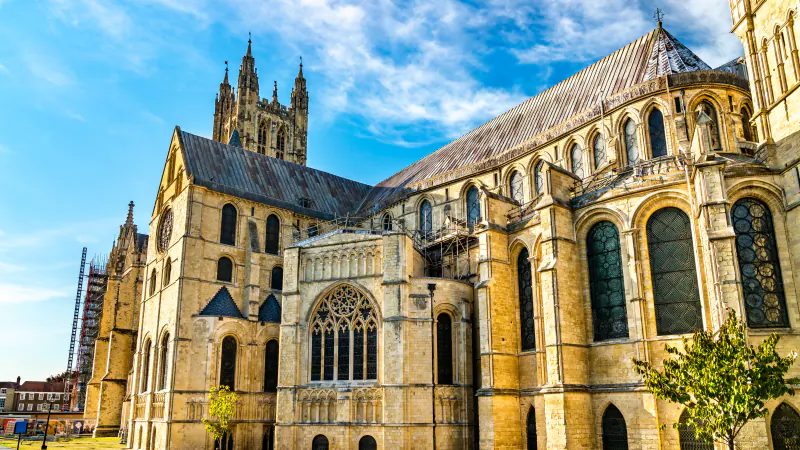 Canterbury Cathedral, its stone towers and stained-glass windows under a blue sky