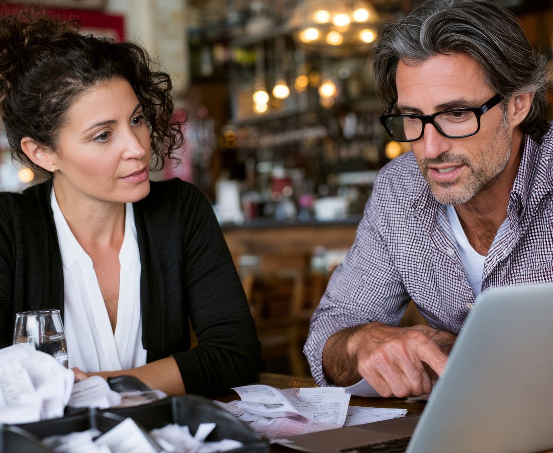 An adviser going through figures on a laptop with a small business owner