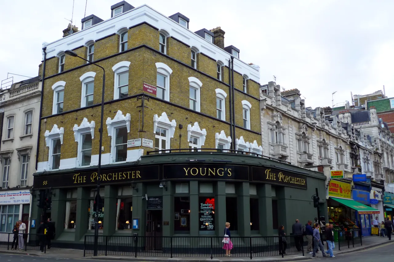 The Porchester pub on Bishops Bridge Road, Bayswater, with shops and pedestrians