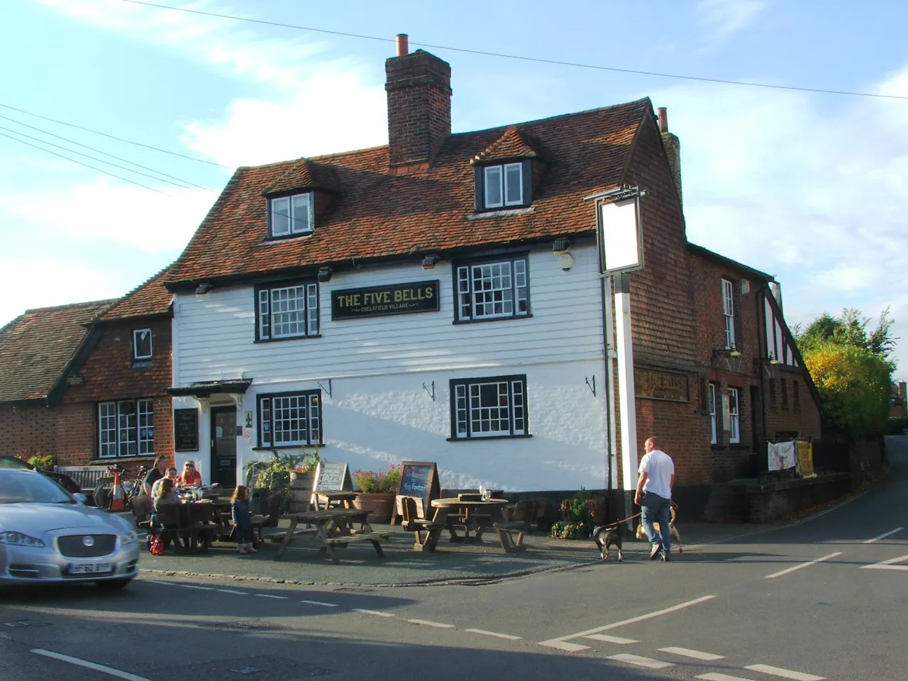 The Five Bells pub on the green in Chelsfield village, with people passing by