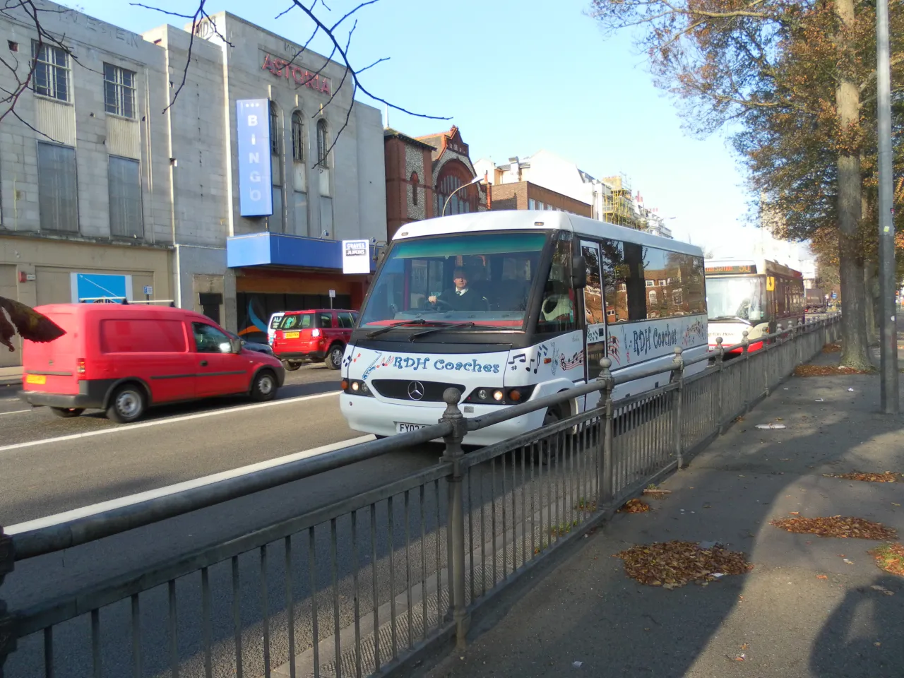 A minibus coach in service on a UK street, the kind of vehicle used for school and group transport work