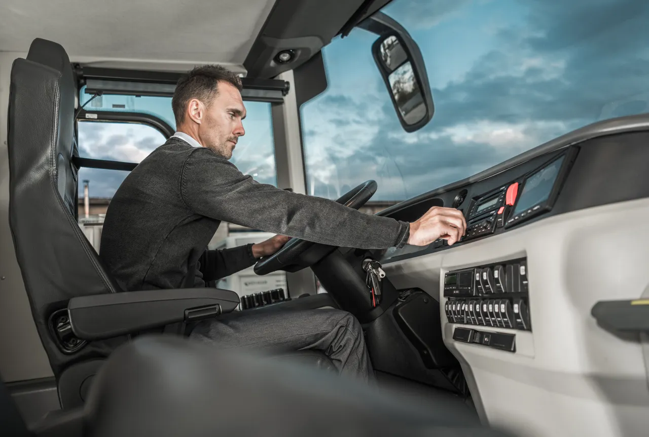 A coach driver at the wheel, focused on the road, mid-journey