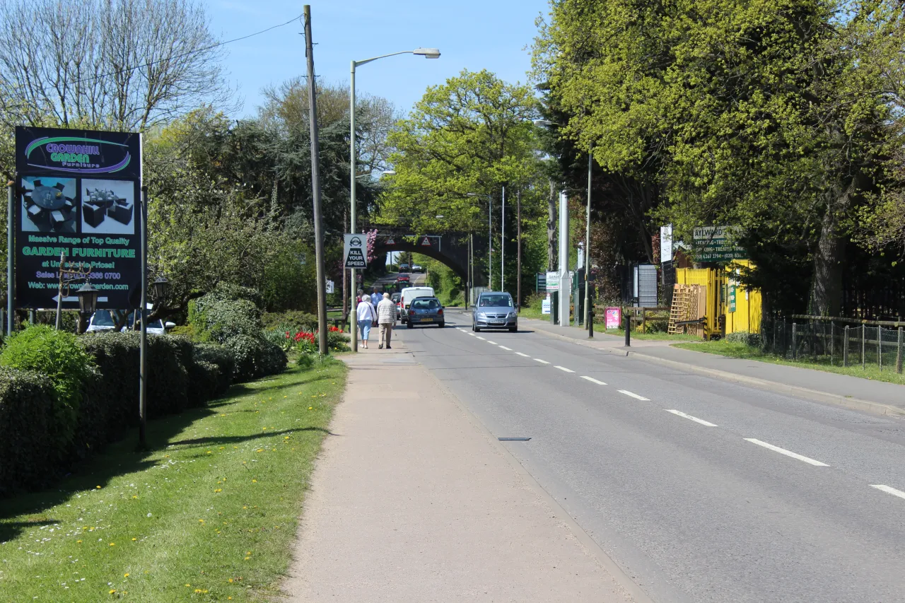 Cattlegate Road in Crews Hill, lined with garden centre signs and greenery