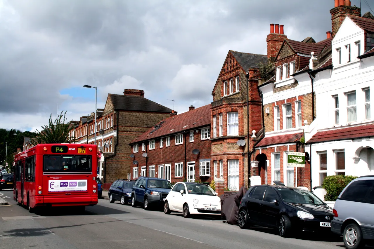 Honor Oak Park high street, London SE23, with shops, terraced houses and a bus