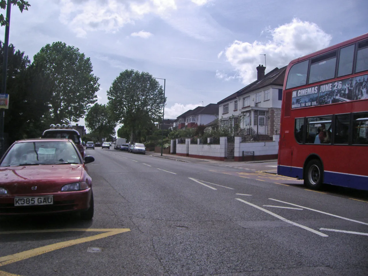 Dollis Hill Lane with passing traffic and a London bus