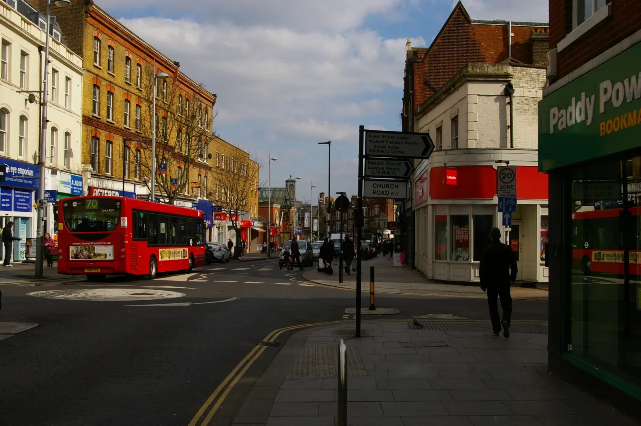 Acton High Street with shops, a bus and pedestrians, London