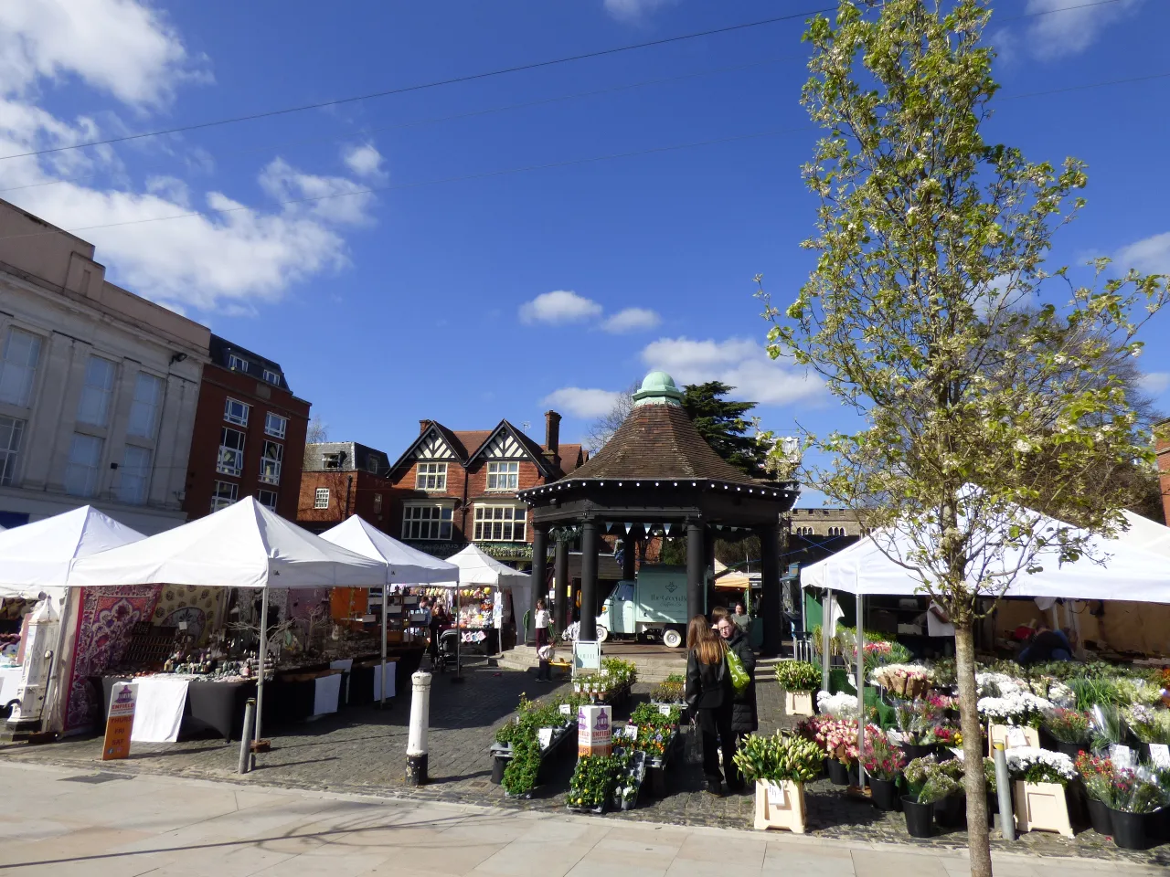 Market Place, Enfield Town, with the market cross and stalls on a sunny day Market Place