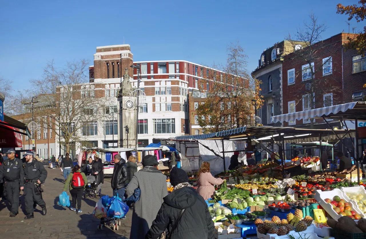 Lewisham Market, with fruit and veg stalls and shoppers in the town centre
