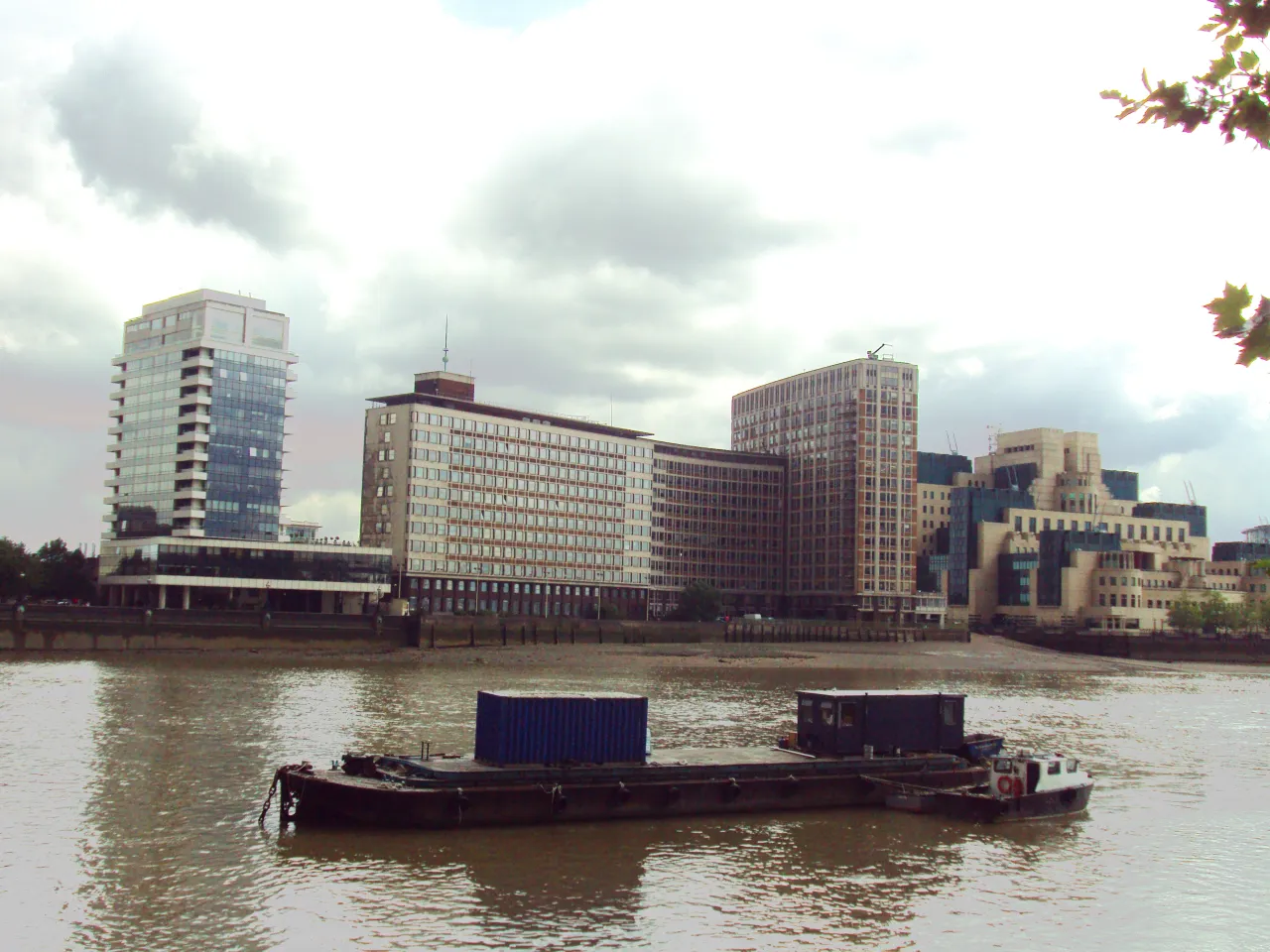 The Thames viewed from Millbank, with a barge passing and the SIS building opposite