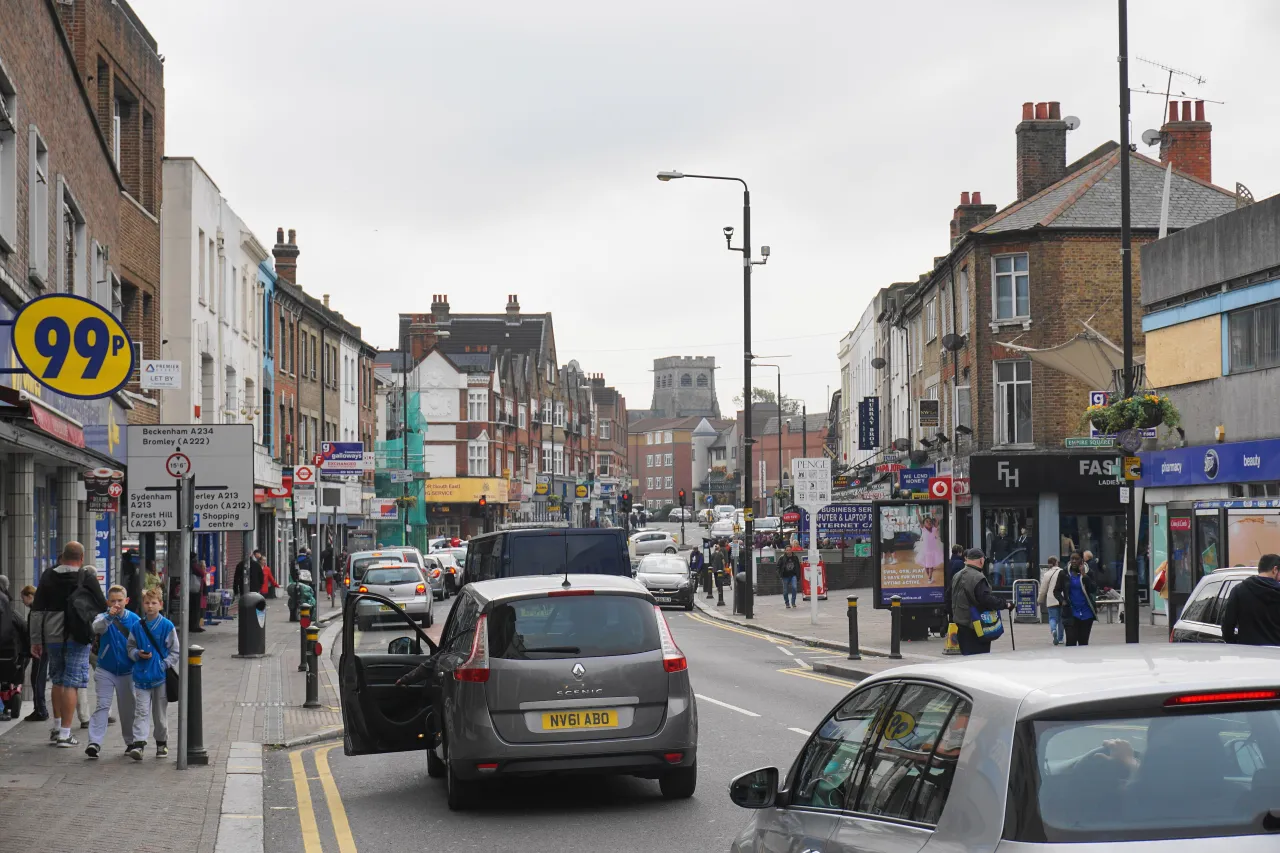 Penge High Street with shoppers, shops and traffic