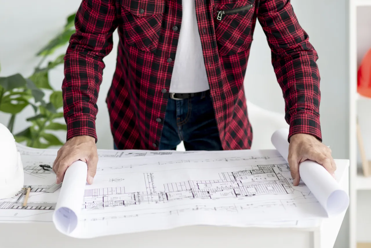 Planning consultant standing at his desk, plans open, working through the details of a case
