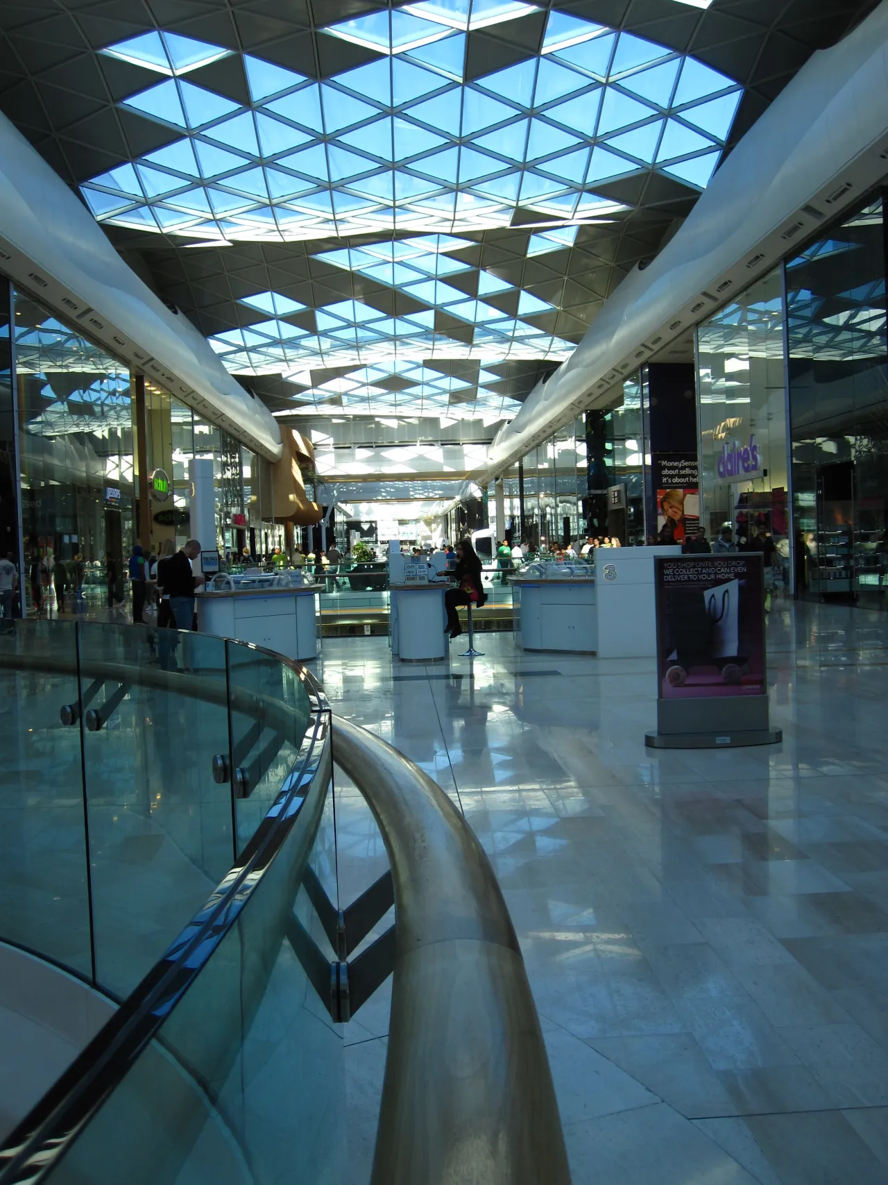 Interior of Westfield London shopping centre with shoppers and glass roof