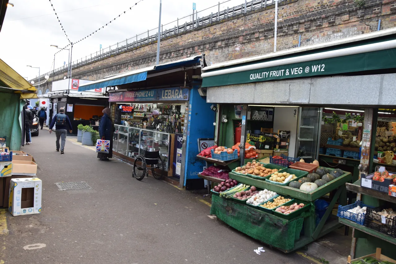 Shepherds Bush Market stalls and shops with shoppers, fresh produce on display