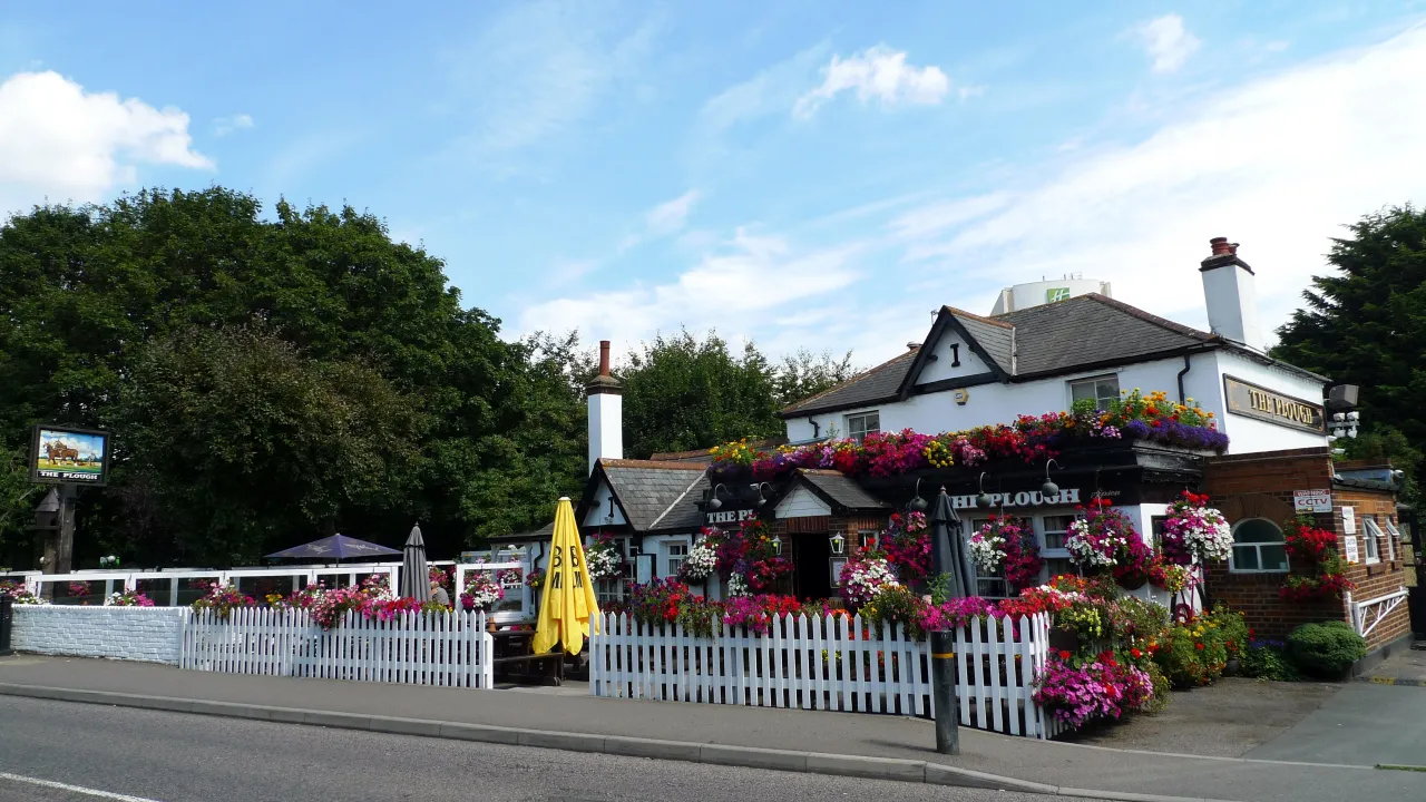 The Plough pub with hanging flower baskets on Sipson Road
