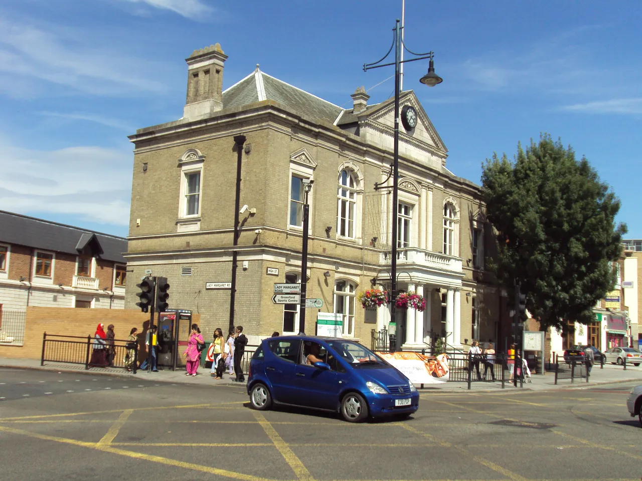 The old town hall on High Street in Southall, Ealing, with traffic and pedestrians outside