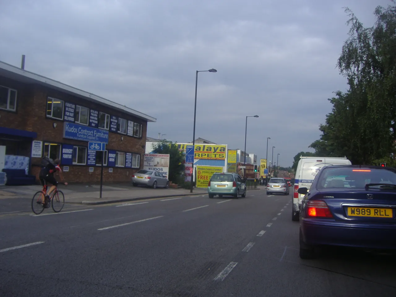 Uxbridge Road in Southall, Ealing, with local shops, traffic and a cyclist