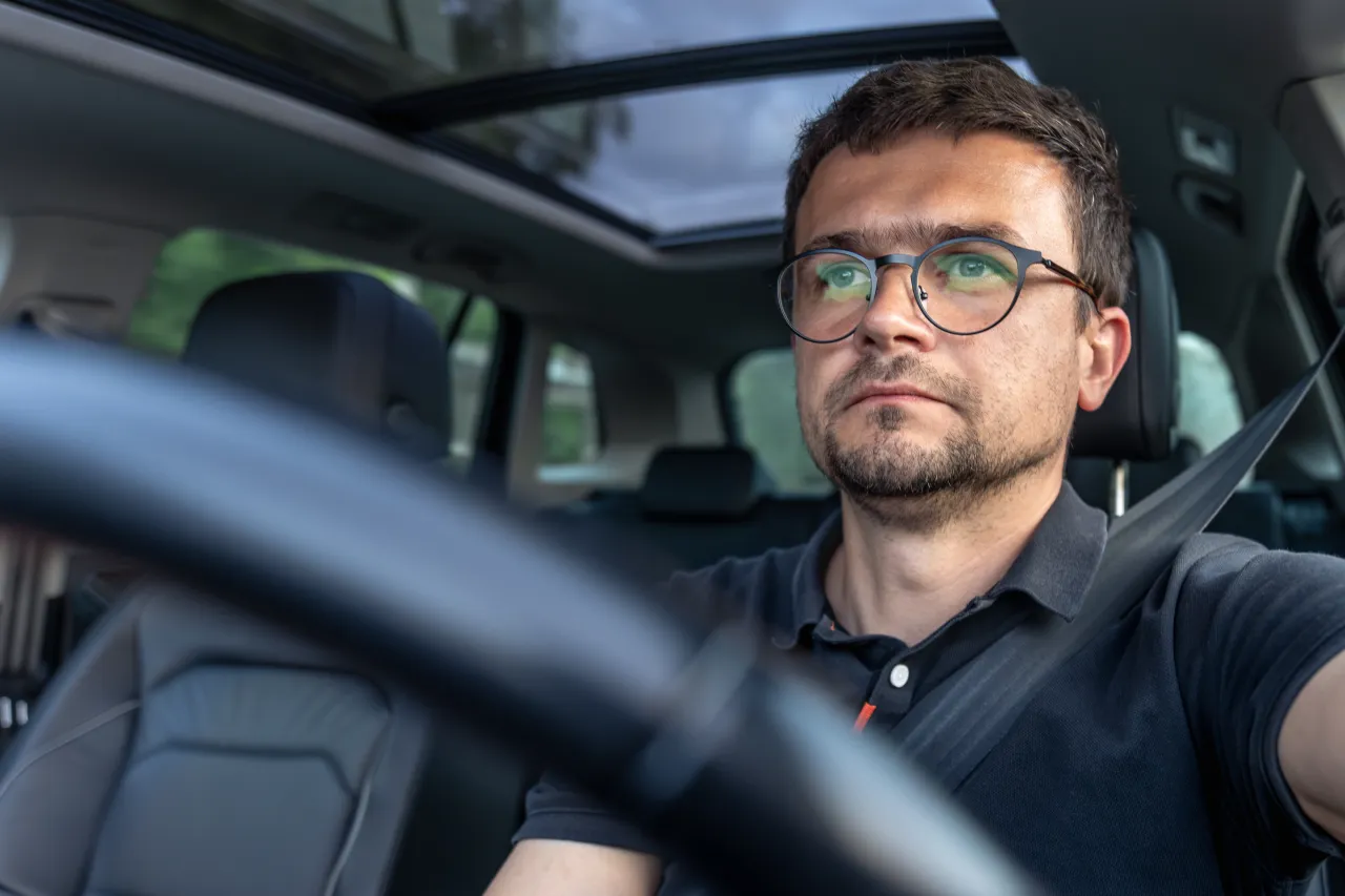A driver focused on the road, hands on the wheel, working
