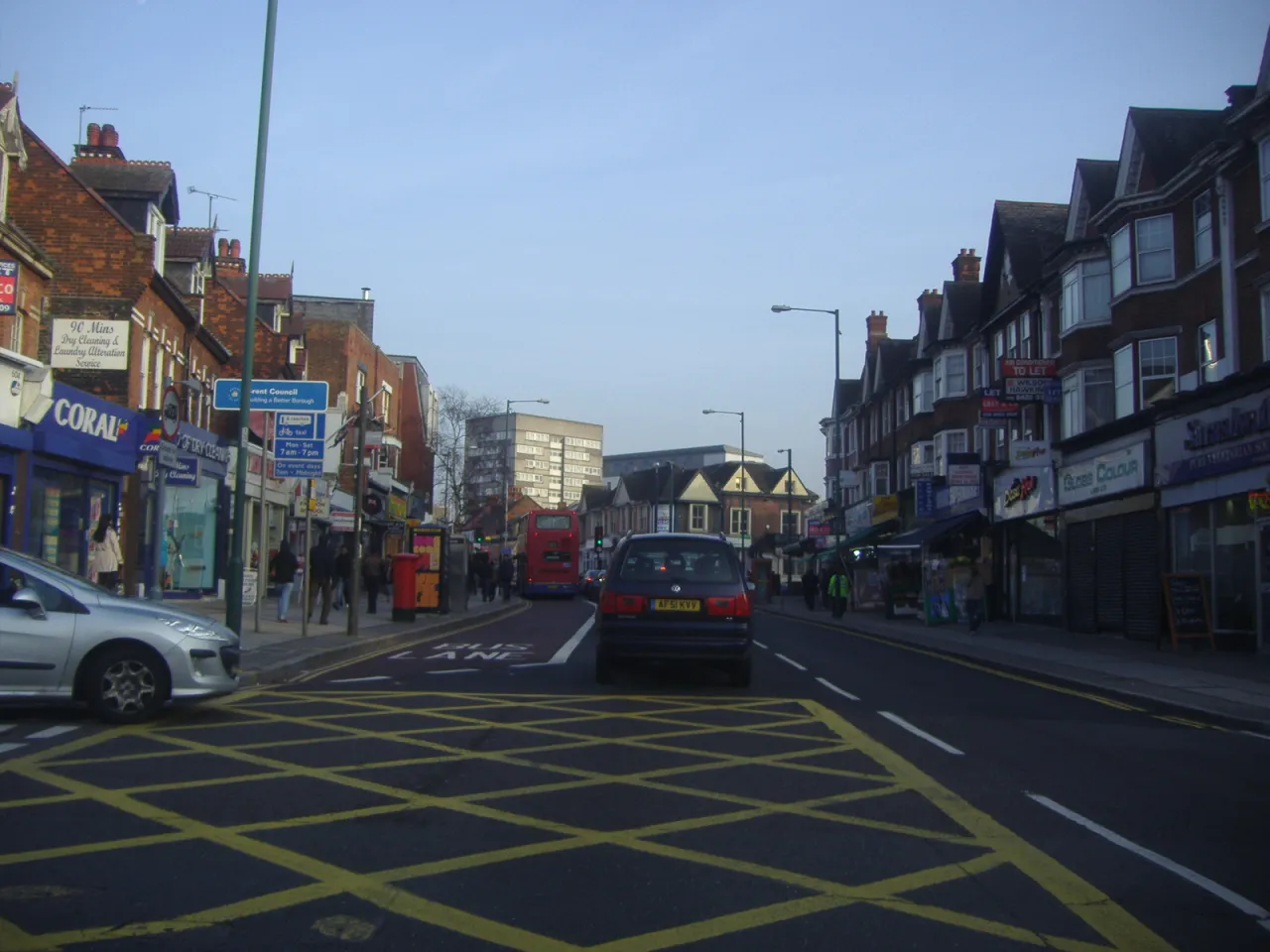 Wembley High Road with buses and shops on a clear day