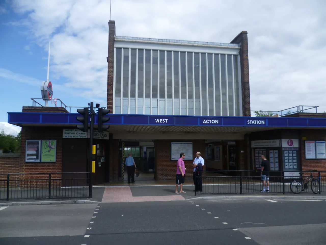 West Acton Underground station building on the Central line, with pedestrians outside