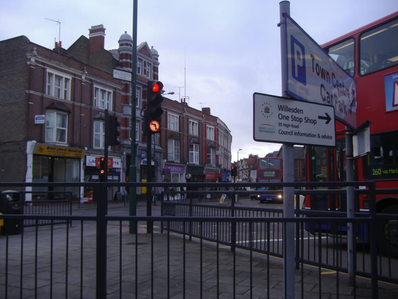 The Walm Lane and Willesden Lane junction in Willesden Green, with local shops and buses