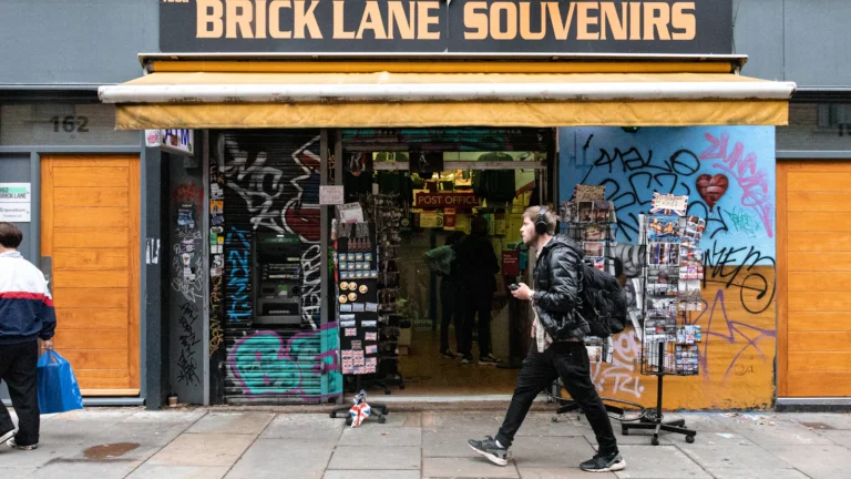 Shoppers walking past a small independent shop on Brick Lane in London